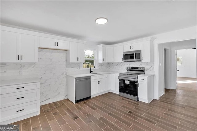 kitchen featuring appliances with stainless steel finishes, sink, decorative backsplash, and white cabinets