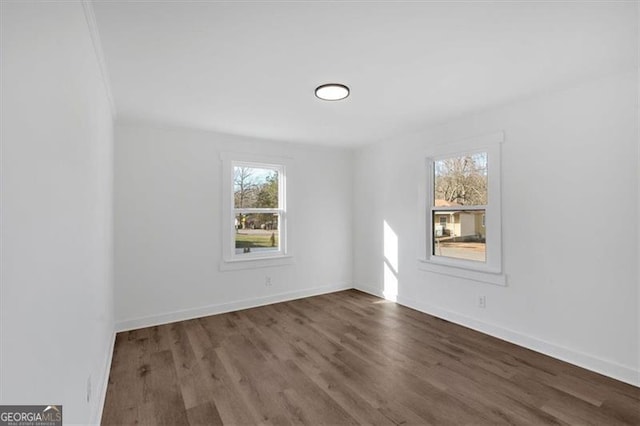 unfurnished room with dark hardwood / wood-style flooring