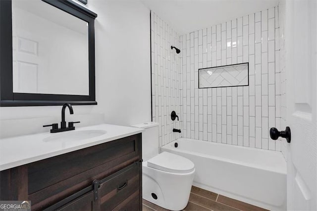 full bathroom with tiled shower / bath, vanity, and toilet