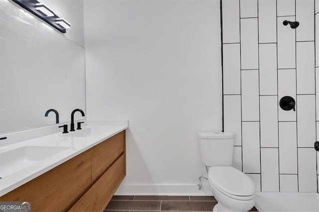 bathroom featuring vanity, toilet, and a shower