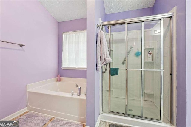 bathroom with shower with separate bathtub and a textured ceiling