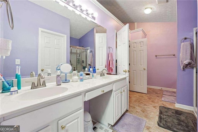 bathroom with a shower with door, vanity, tile patterned flooring, and a textured ceiling