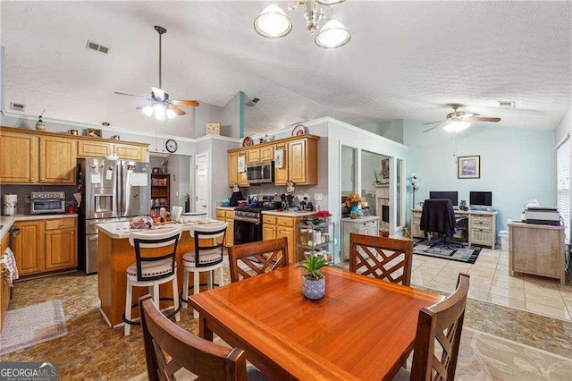 tiled dining room with ceiling fan, high vaulted ceiling, and a textured ceiling