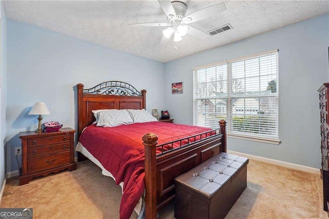 carpeted bedroom featuring a textured ceiling and ceiling fan