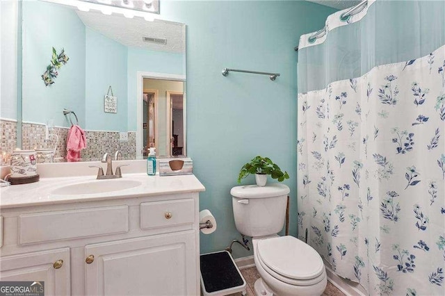 bathroom featuring walk in shower, vanity, toilet, and decorative backsplash