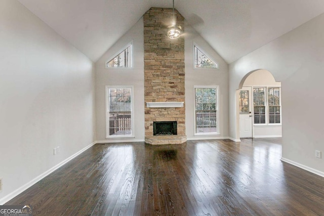 unfurnished living room with dark hardwood / wood-style floors, a fireplace, and high vaulted ceiling