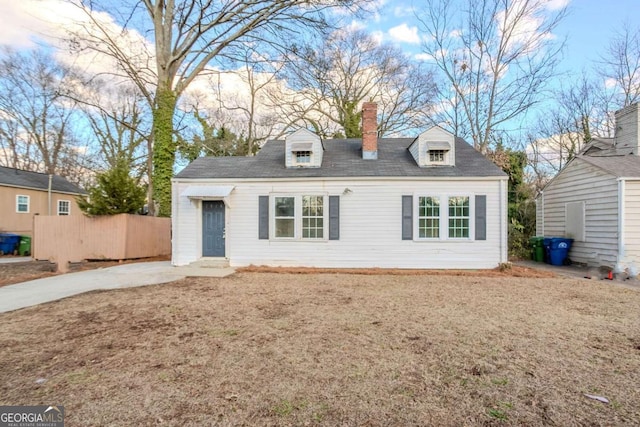 cape cod home featuring a front lawn