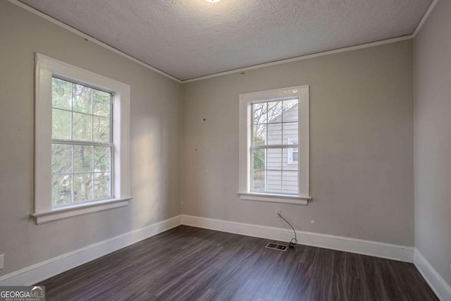 spare room featuring plenty of natural light, ornamental molding, dark hardwood / wood-style floors, and a textured ceiling