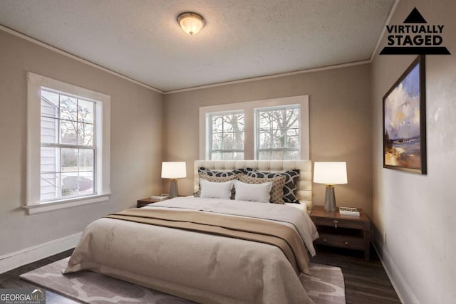 bedroom featuring crown molding, dark wood-type flooring, and a textured ceiling