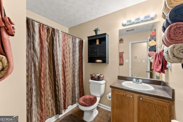 bathroom featuring vanity, a textured ceiling, and toilet