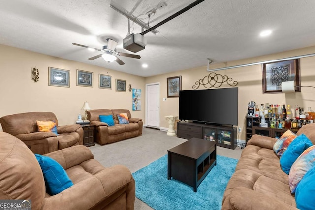 living room featuring light carpet, ceiling fan, and a textured ceiling