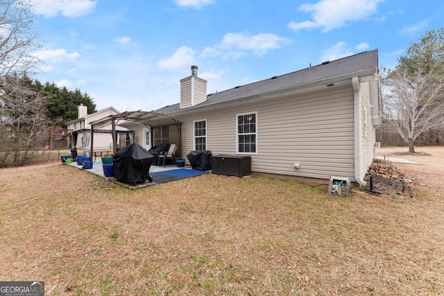 rear view of property with a lawn, a patio area, and a pergola