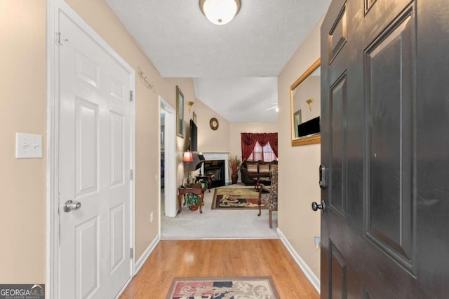 foyer entrance featuring a textured ceiling and light wood-type flooring