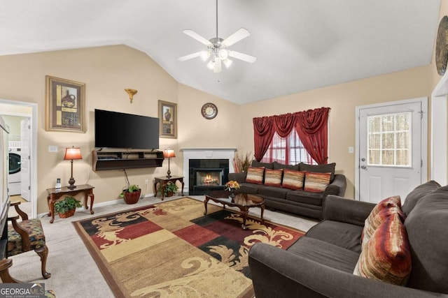 living room with lofted ceiling, a tile fireplace, ceiling fan, washer / clothes dryer, and carpet