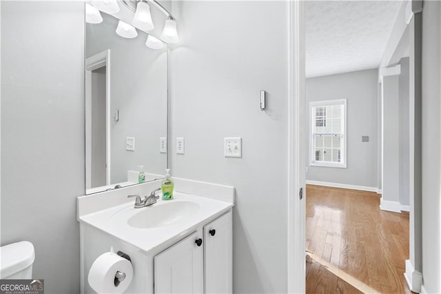 bathroom with vanity, hardwood / wood-style floors, and toilet