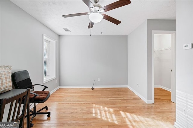 office area featuring ceiling fan, light hardwood / wood-style floors, and a textured ceiling