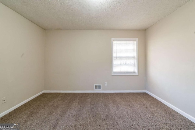 carpeted spare room with a textured ceiling