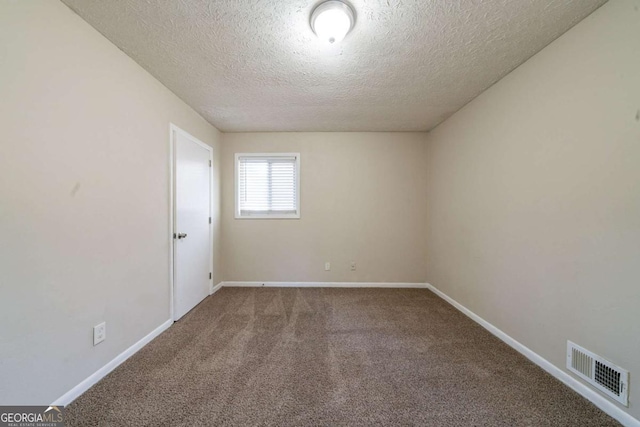 carpeted empty room with a textured ceiling