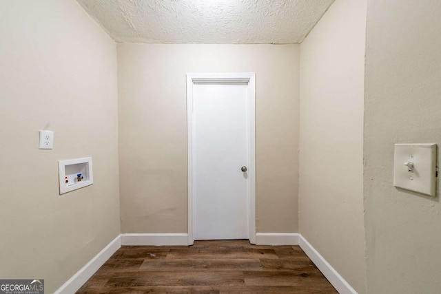 washroom featuring washer hookup, dark hardwood / wood-style flooring, and a textured ceiling