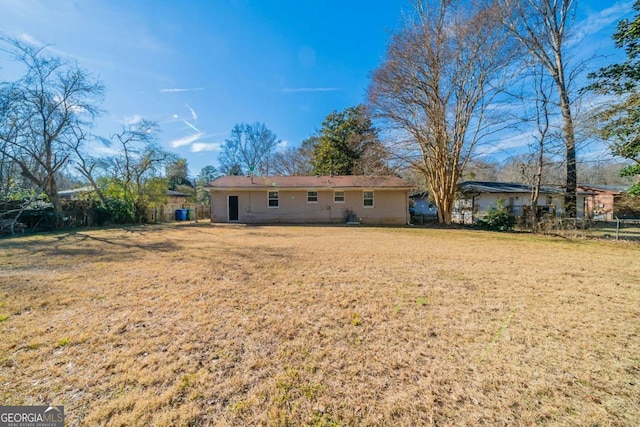 back of house with a lawn