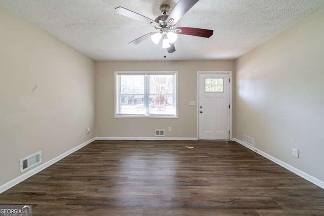 entrance foyer featuring dark hardwood / wood-style flooring, plenty of natural light, and a textured ceiling