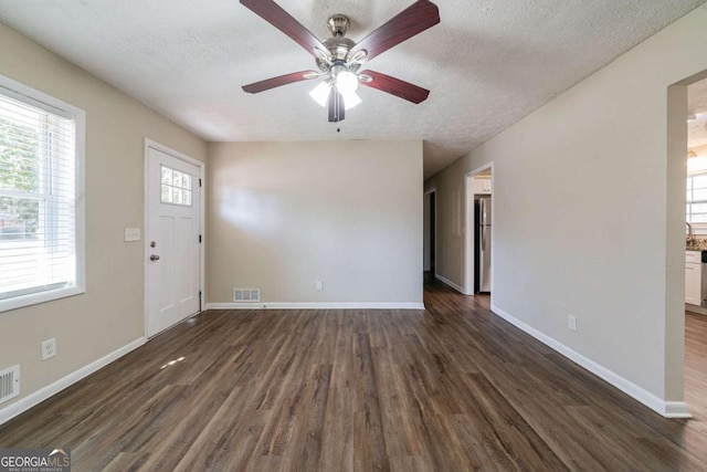 entryway with ceiling fan, a textured ceiling, and dark hardwood / wood-style flooring