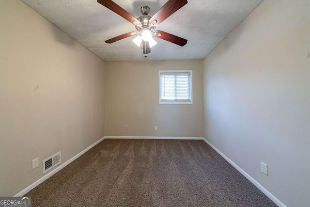 empty room with ceiling fan, dark carpet, and a textured ceiling