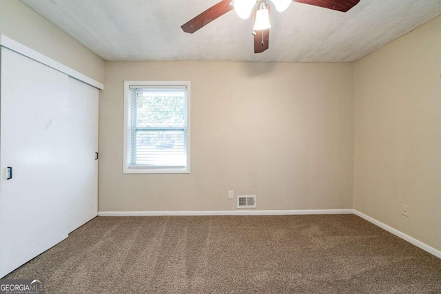 spare room with ceiling fan, carpet floors, and a textured ceiling