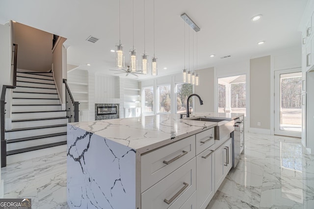 1785 Traditions Way, Jefferson, GA 30549 - kitchen featuring a sink, a large fireplace, white cabinets, light marble finish floors, and recessed lighting