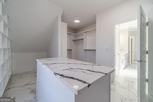 walk in closet with marble finish floor