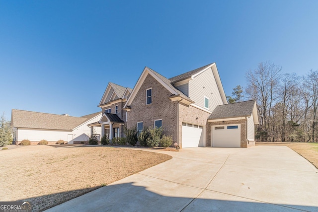 view of front of house featuring a garage, concrete driveway, and brick siding