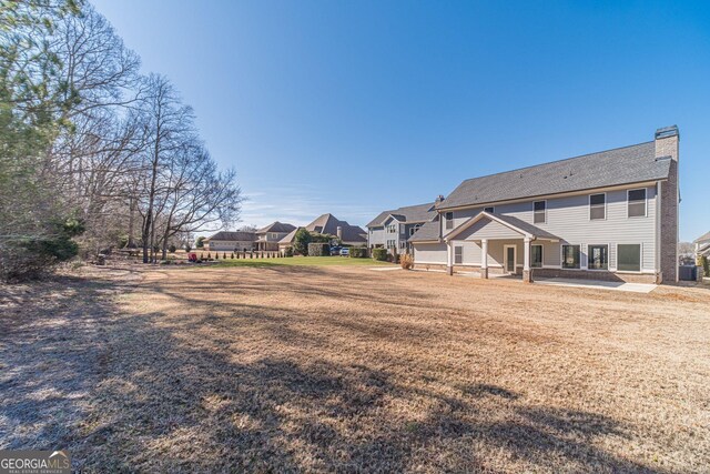 rear view of property with a yard and a patio area