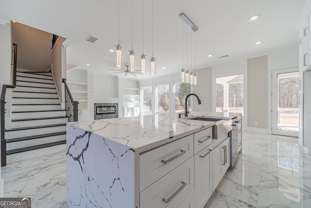 kitchen with recessed lighting, a large fireplace, visible vents, and white cabinetry