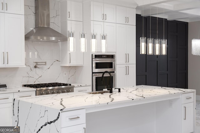 kitchen with white cabinets, stove, wall chimney range hood, double oven, and a sink