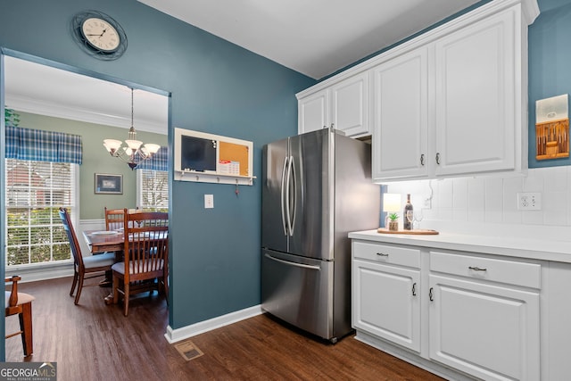 kitchen with tasteful backsplash, dark hardwood / wood-style flooring, stainless steel fridge, and white cabinets