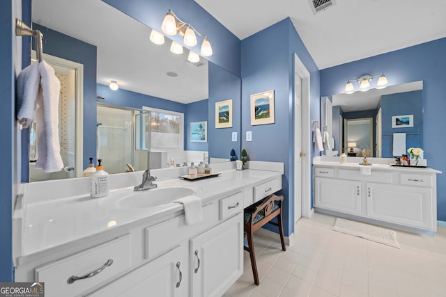 bathroom with tile patterned flooring, vanity, and walk in shower