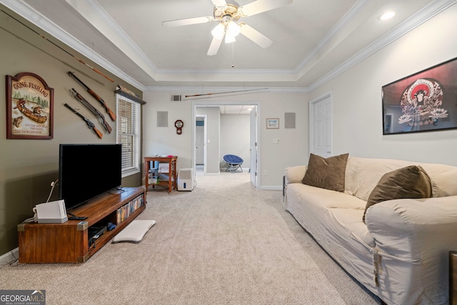 living room with ceiling fan, light colored carpet, ornamental molding, and a tray ceiling