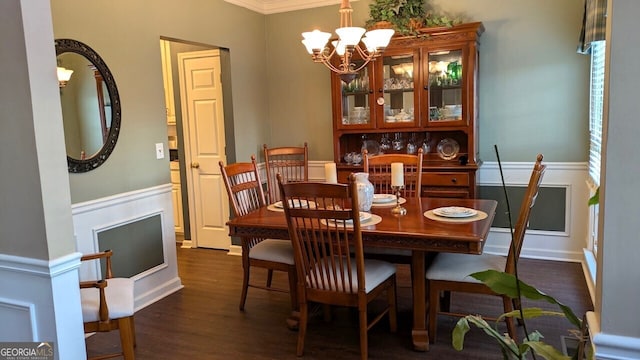 dining room with dark wood-type flooring, crown molding, and a chandelier