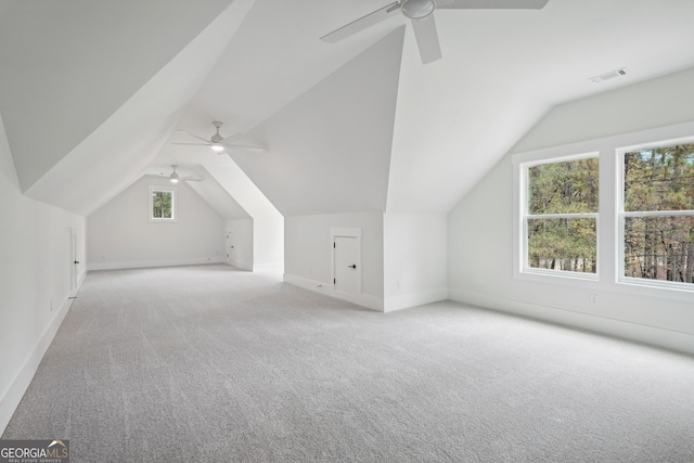 additional living space featuring lofted ceiling, light carpet, and ceiling fan