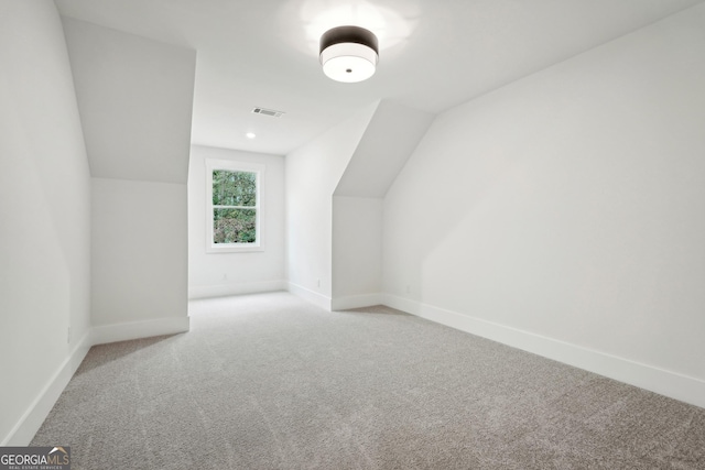 additional living space with lofted ceiling and light carpet