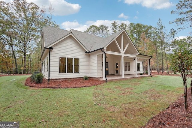 back of property with ceiling fan, a patio area, and a lawn