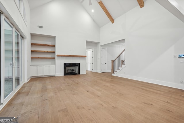 unfurnished living room featuring ceiling fan, beam ceiling, high vaulted ceiling, and light hardwood / wood-style flooring