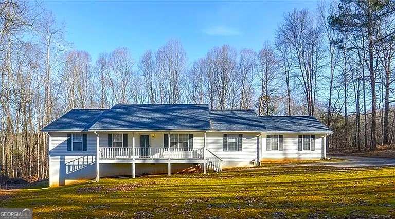 ranch-style house with a front lawn and covered porch