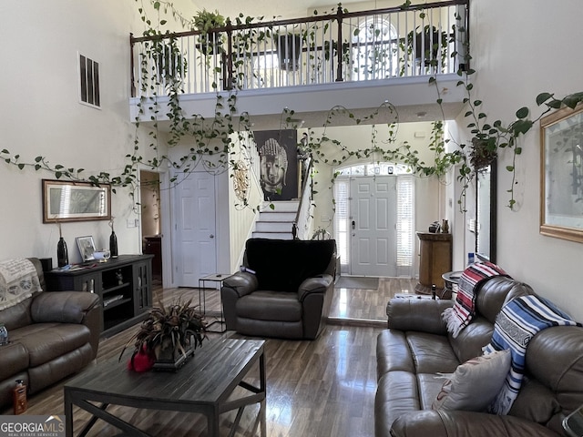 living room with wood-type flooring and a high ceiling