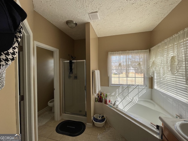 full bathroom with tile patterned flooring, vanity, a textured ceiling, shower with separate bathtub, and toilet