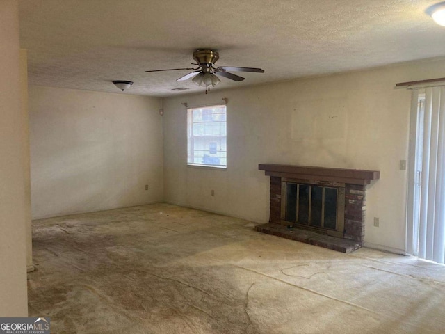 unfurnished living room with ceiling fan, carpet flooring, a textured ceiling, and a fireplace