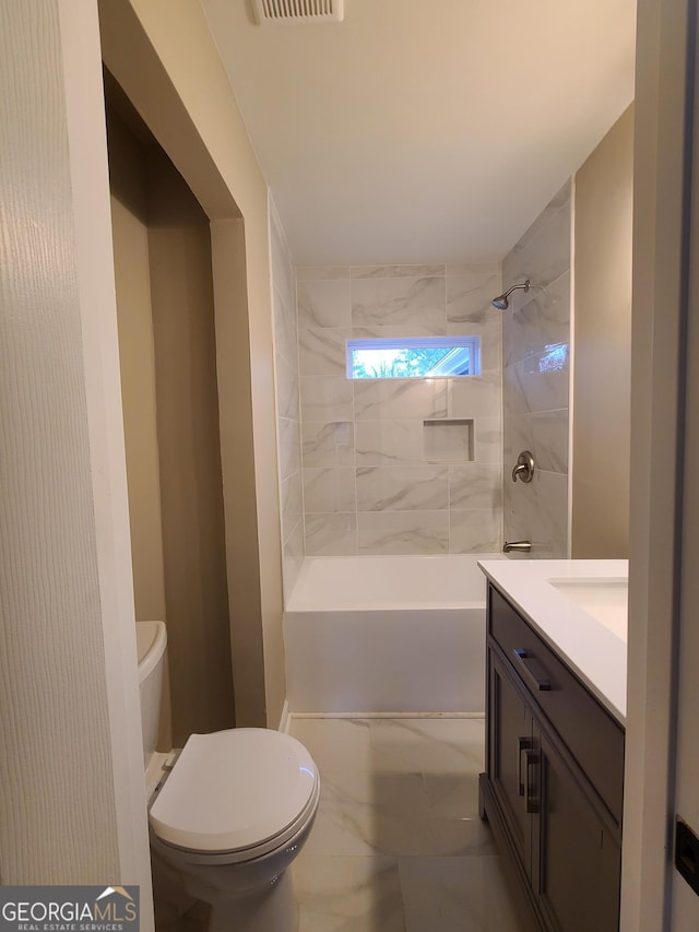 full bathroom with vanity, tiled shower / bath, and toilet