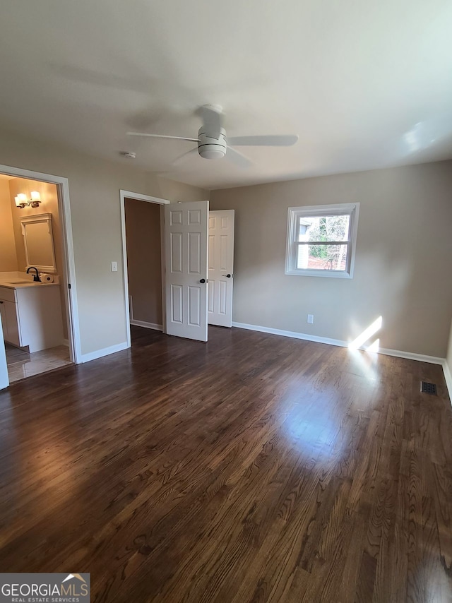 unfurnished bedroom featuring ceiling fan, dark hardwood / wood-style floors, and sink