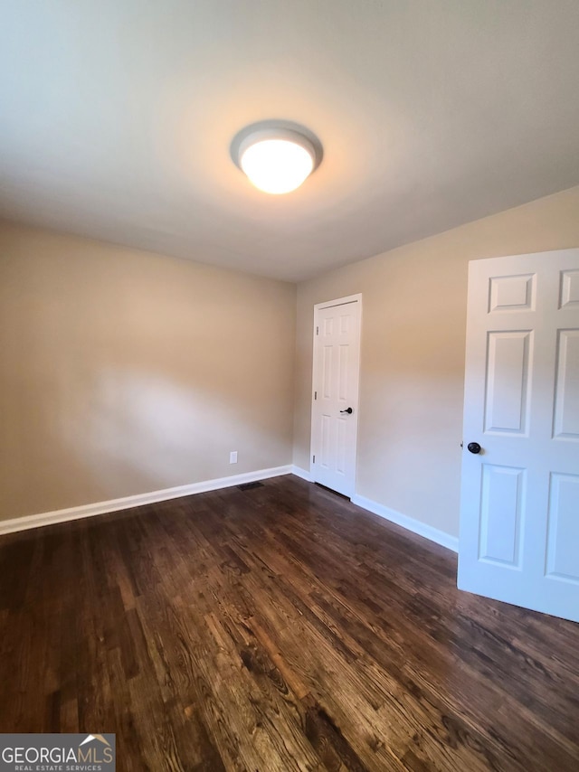 spare room featuring dark hardwood / wood-style flooring