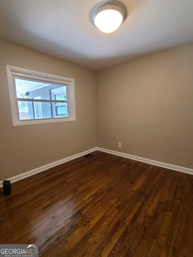 spare room featuring dark hardwood / wood-style flooring